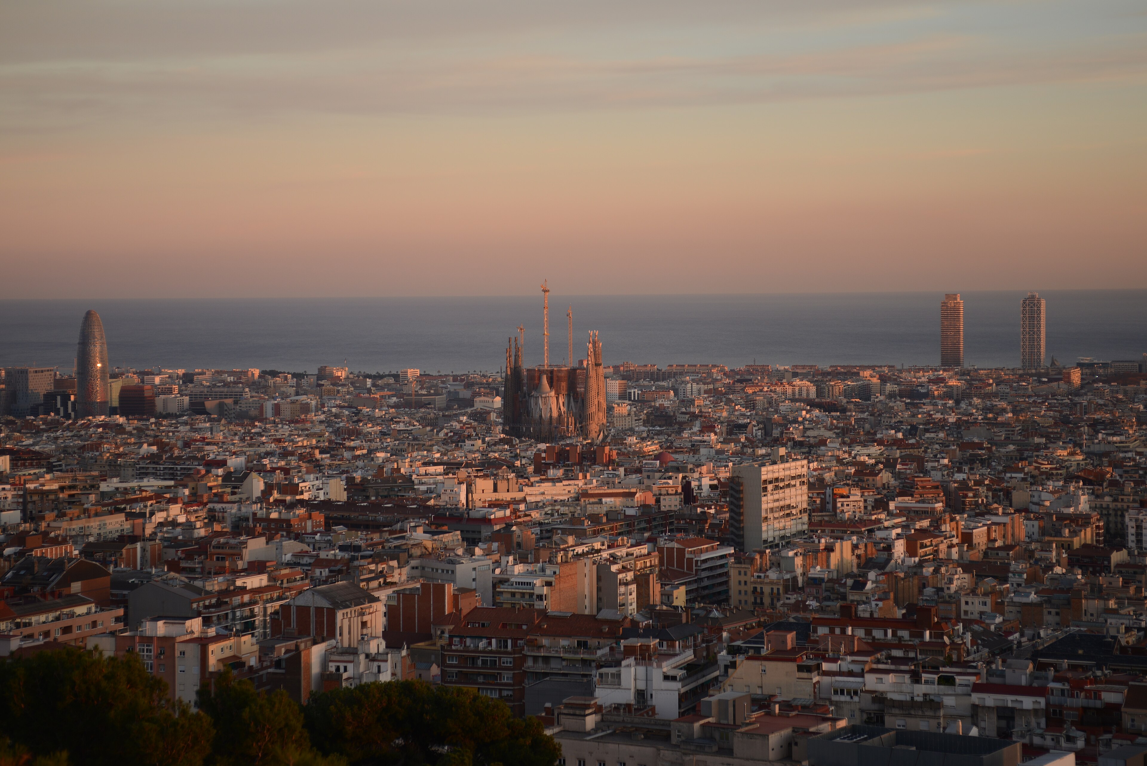 Barcelona skyline at sunset with the Sagrada Familia centered against the Mediterranean
