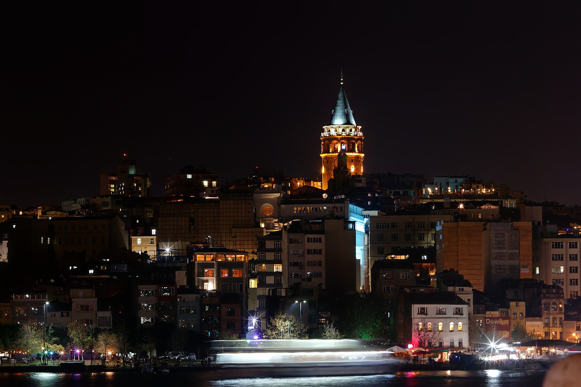Galata Tower lit above the surrounding neighborhood at night in Istanbul