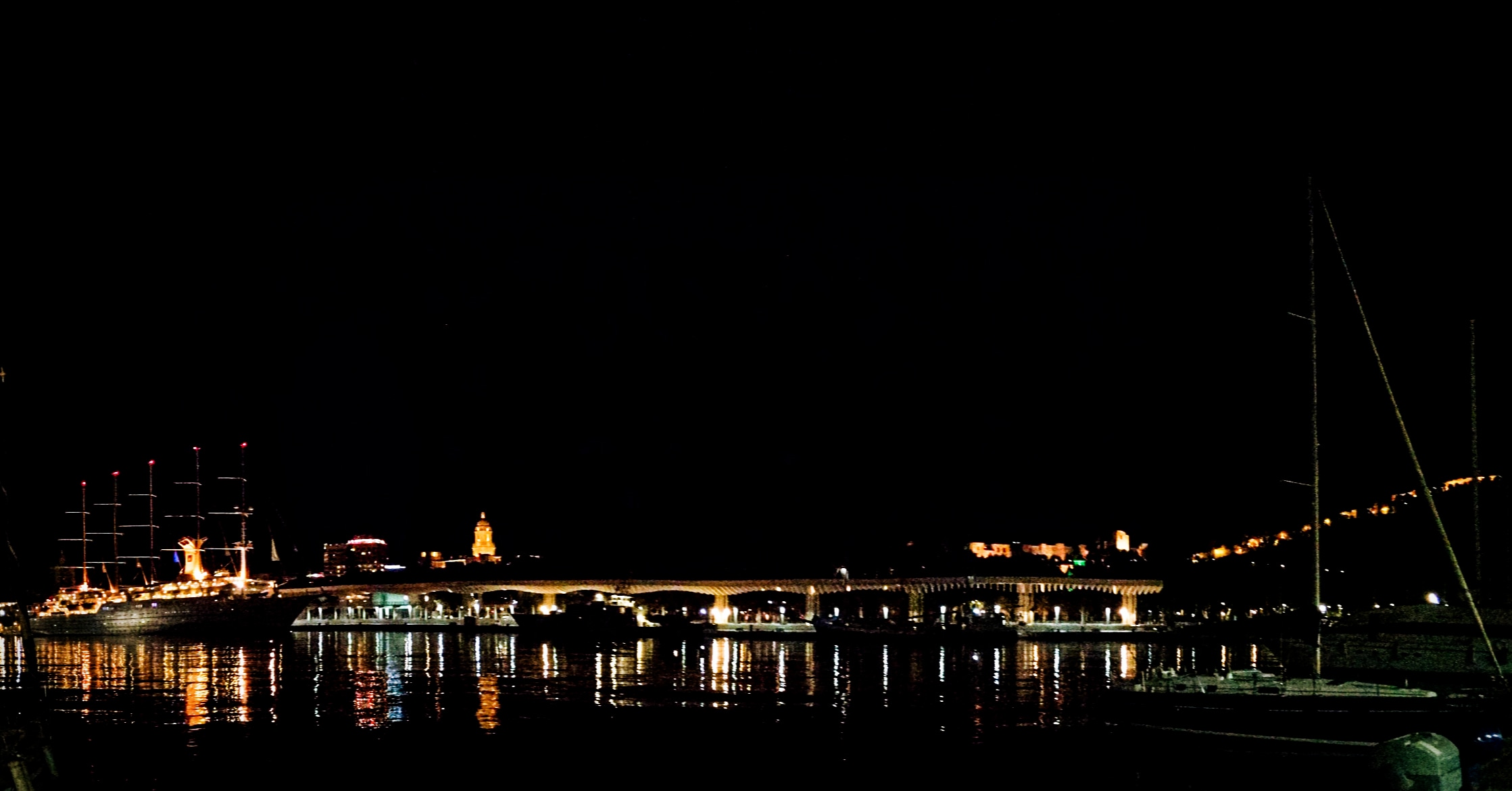 Malaga marina at night with the cathedral and Alcazaba in the background