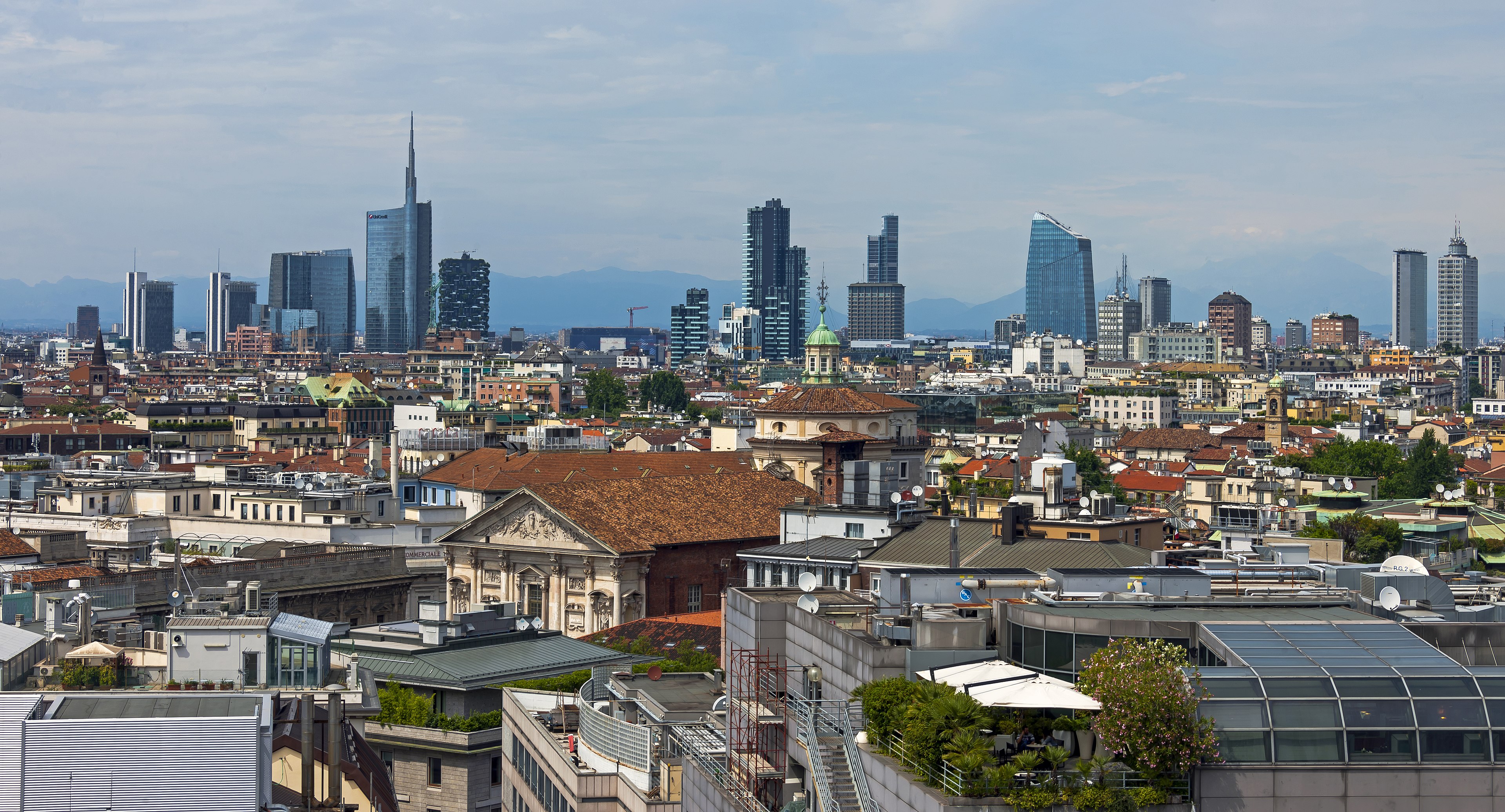 Milan skyline seen from the Duomo roof with modern towers rising beyond the historic center