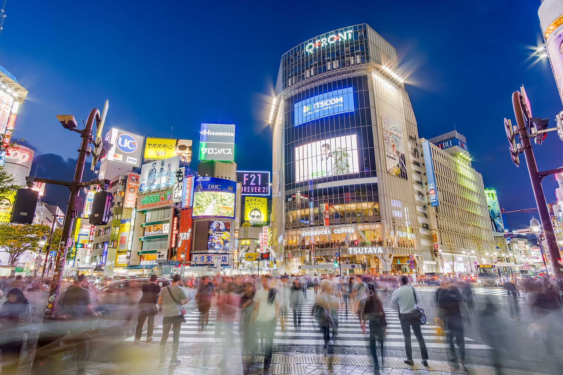 Pedestrians crossing Shibuya Scramble at night in Tokyo
