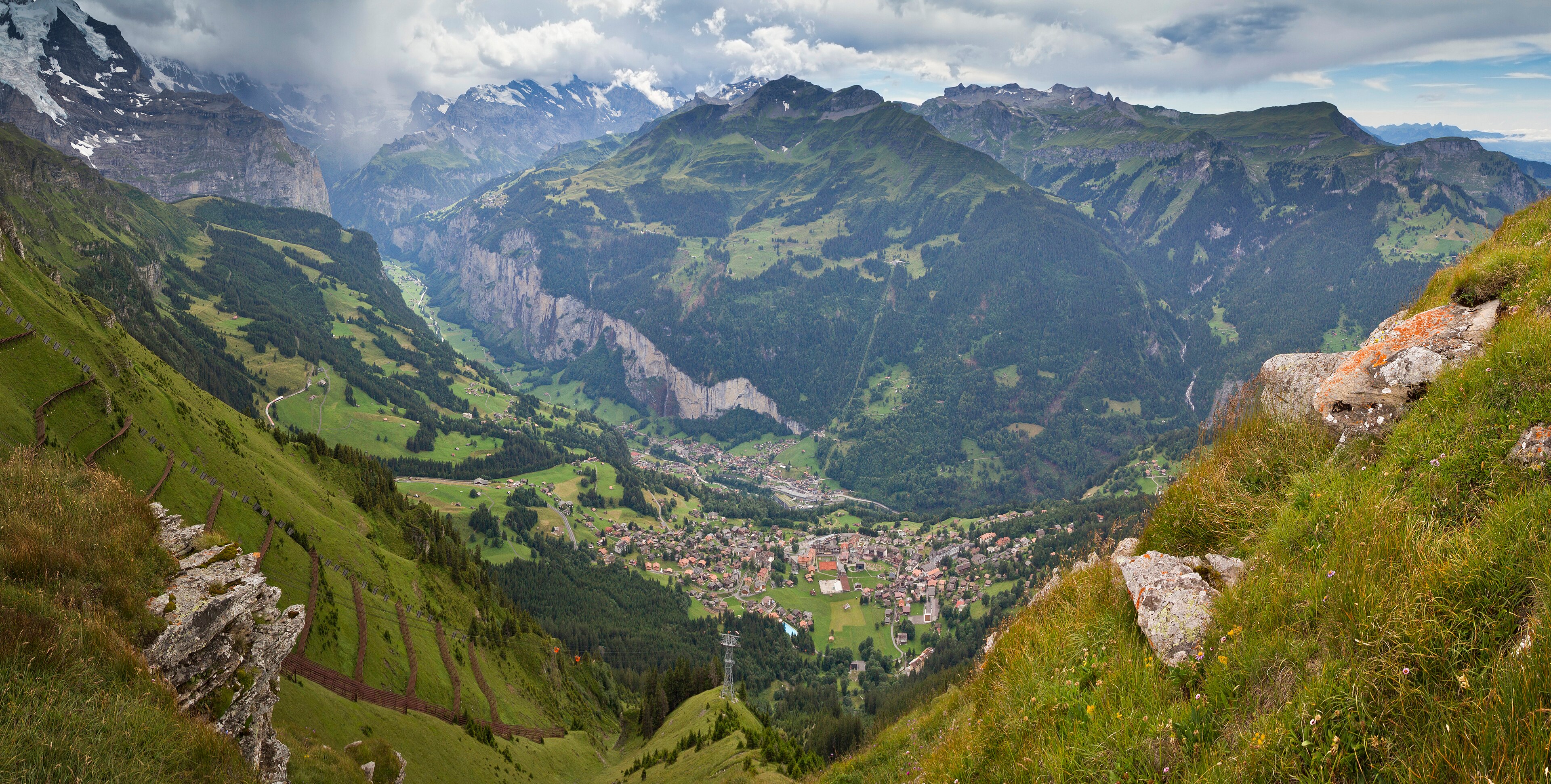 Lauterbrunnen Valley with green slopes and high Alps beyond