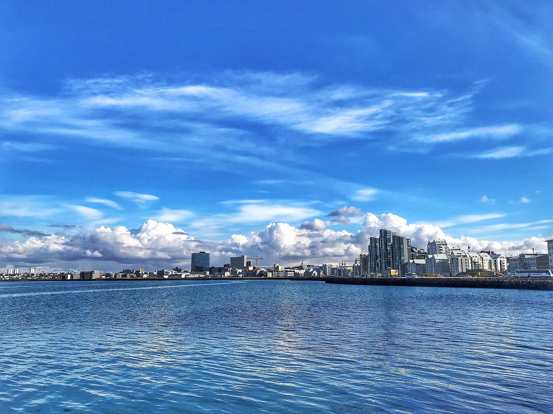 Reykjavik skyline across the bay under bright summer clouds